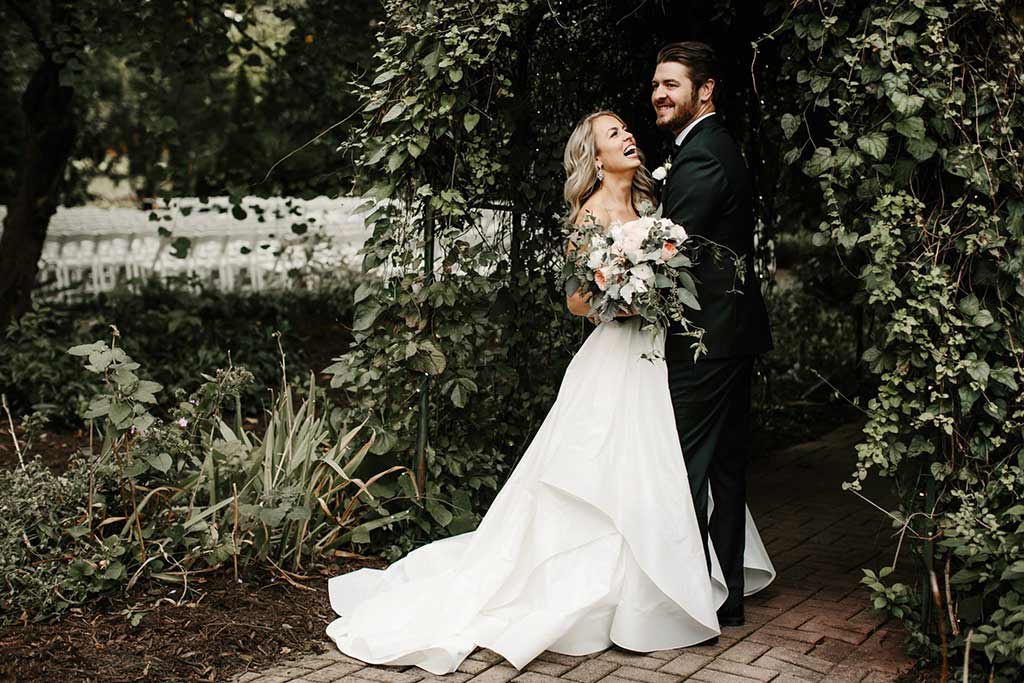 bride wearing custom altered wedding gown and groom wearing custom made tuxedo